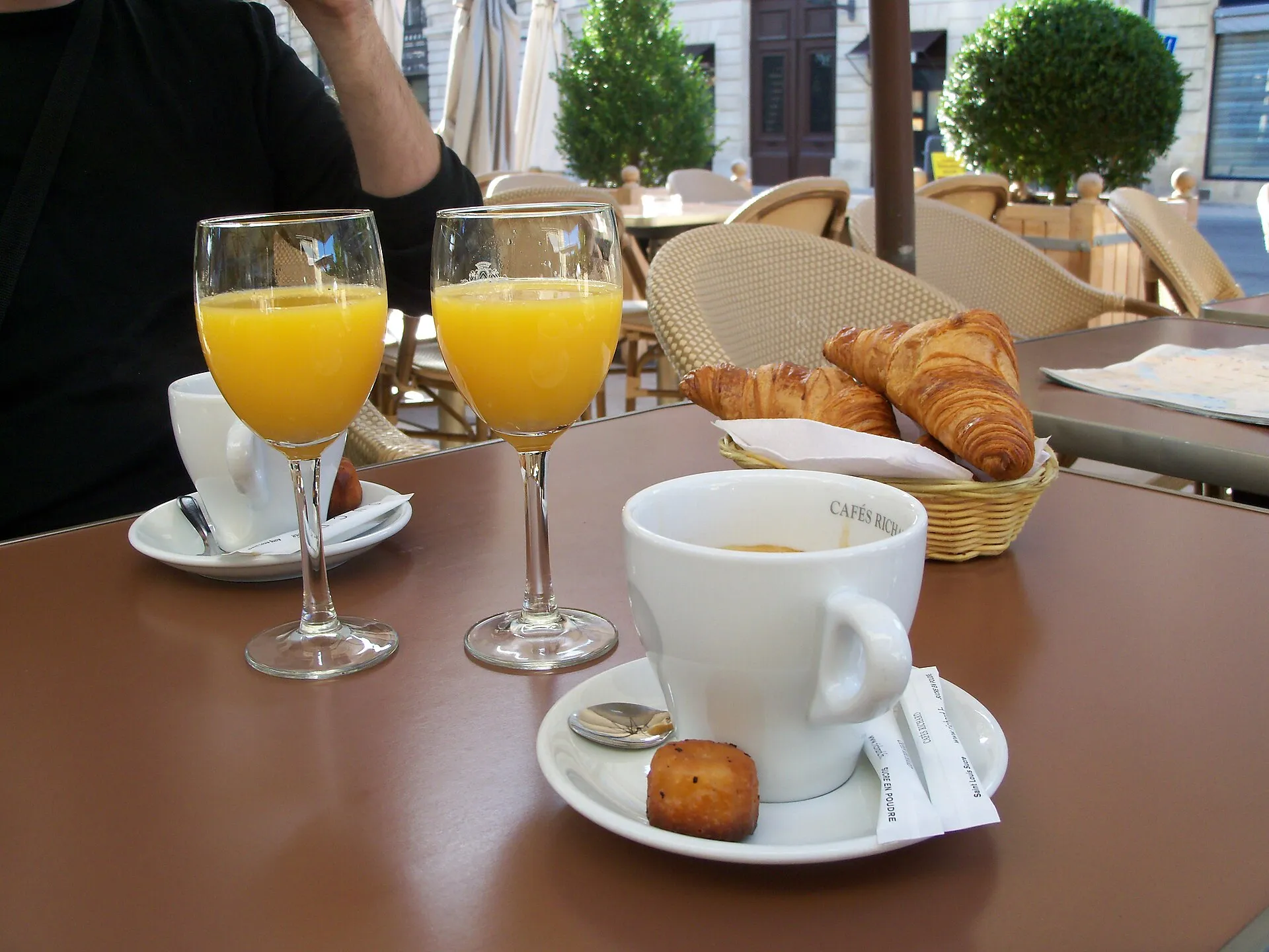 Table de petit-déjeuner avec viennoiseries, confitures et boissons chaudes