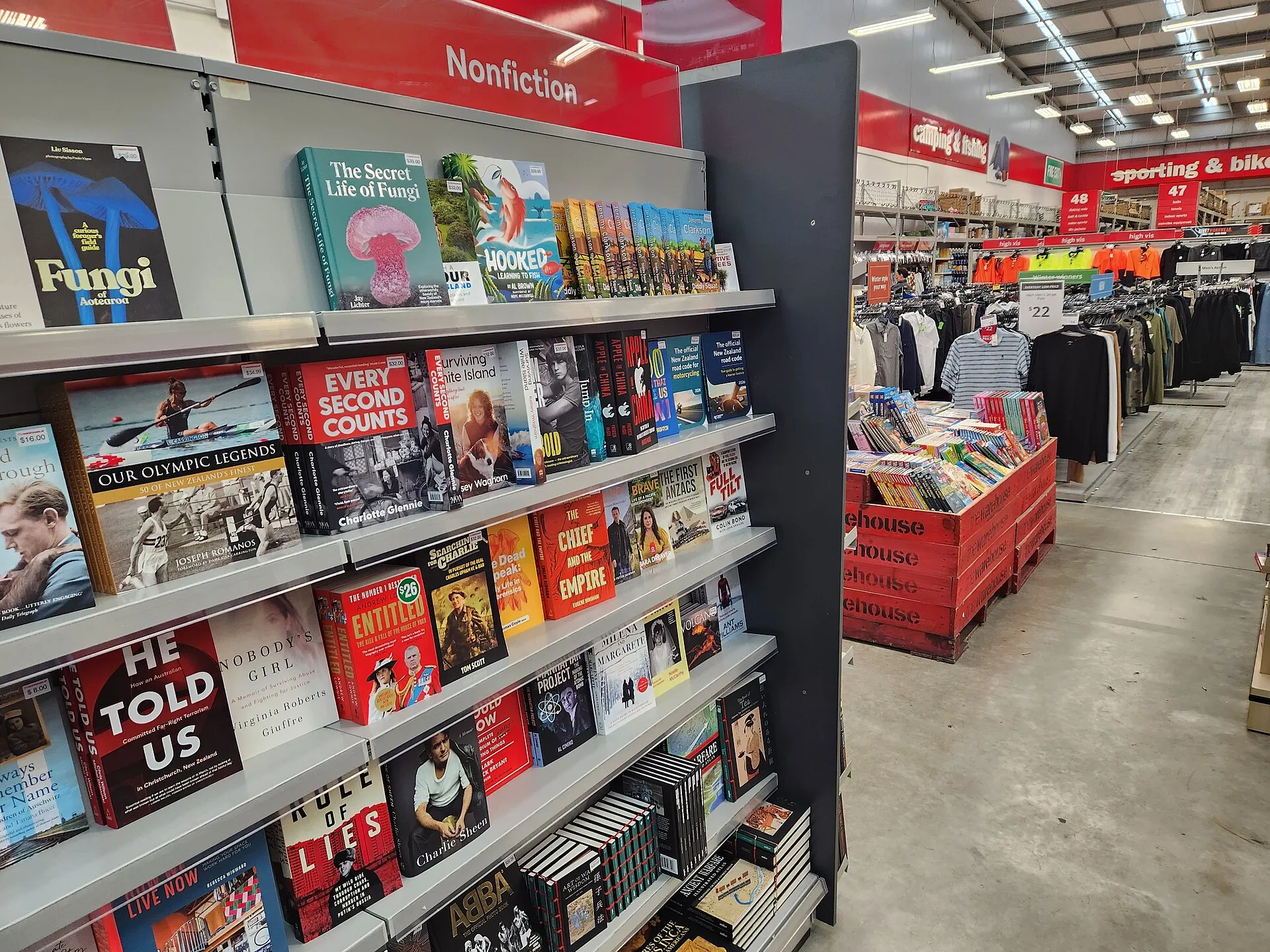 Rayonnages de livres dans une librairie, vus depuis l'allée centrale