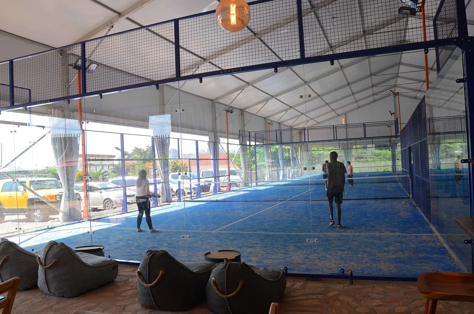 Un court de padel en extérieur, vitres, grille et ligne de service