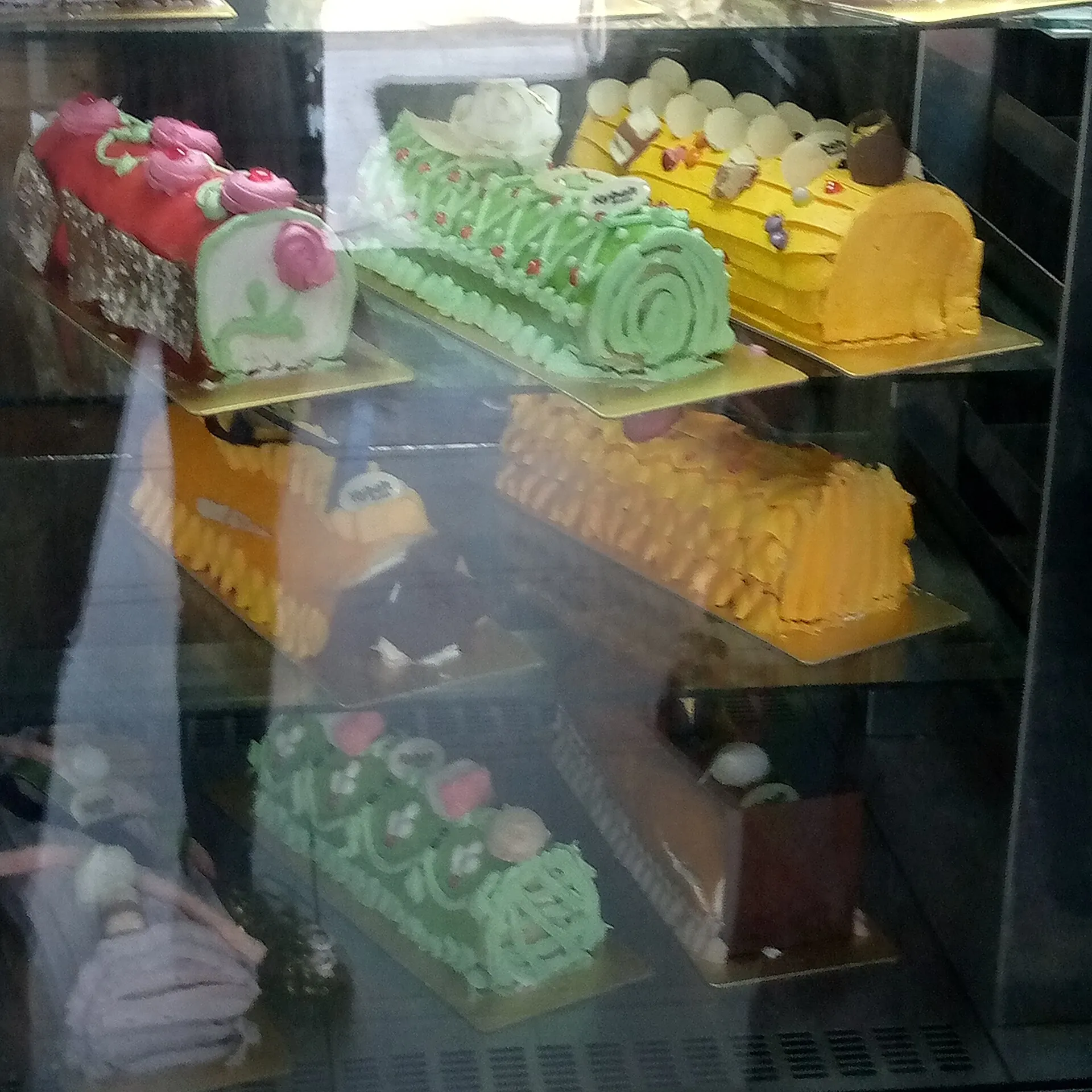 Vitrine de pâtisserie garnie de gâteaux et de tartes vendus à l'unité