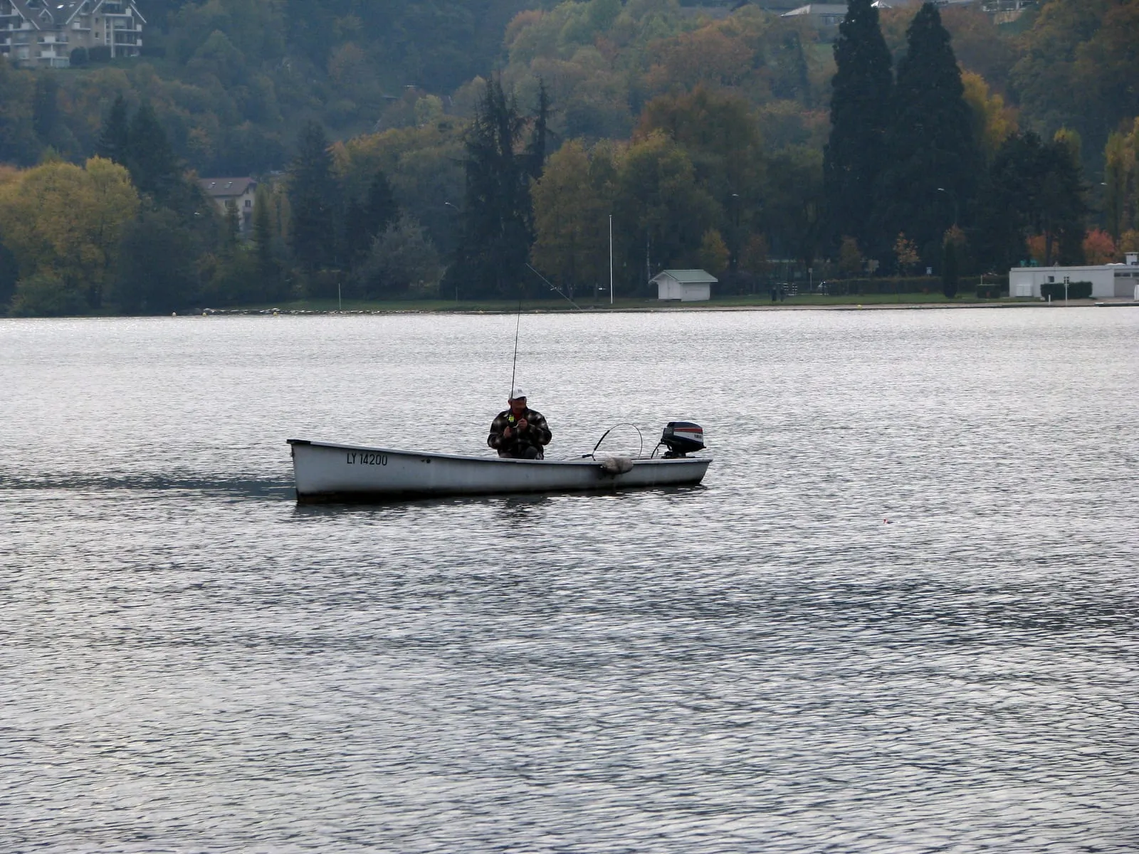 Un pêcheur à la ligne au bord du lac d'Annecy