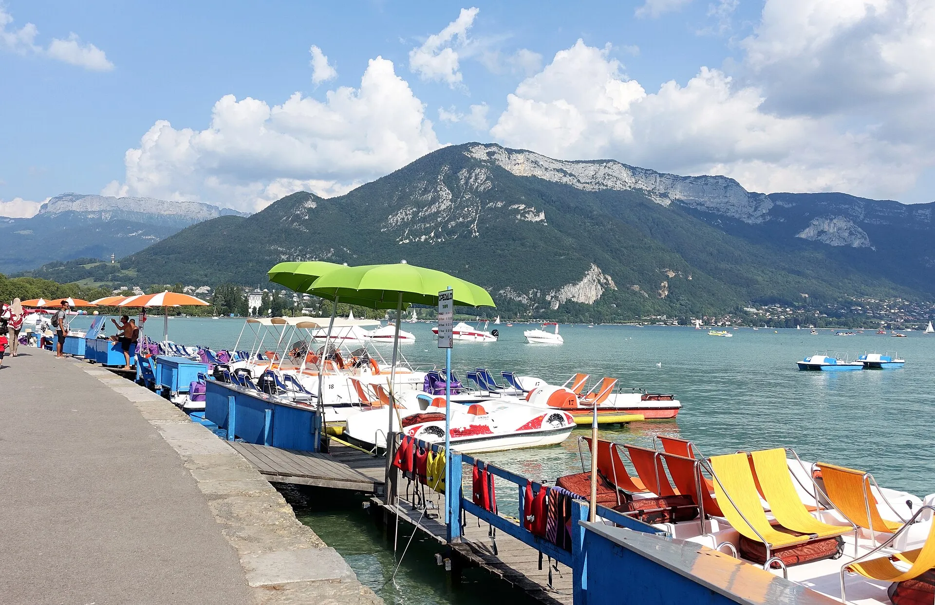 Des pédalos amarrés à un ponton de location sur le lac d'Annecy