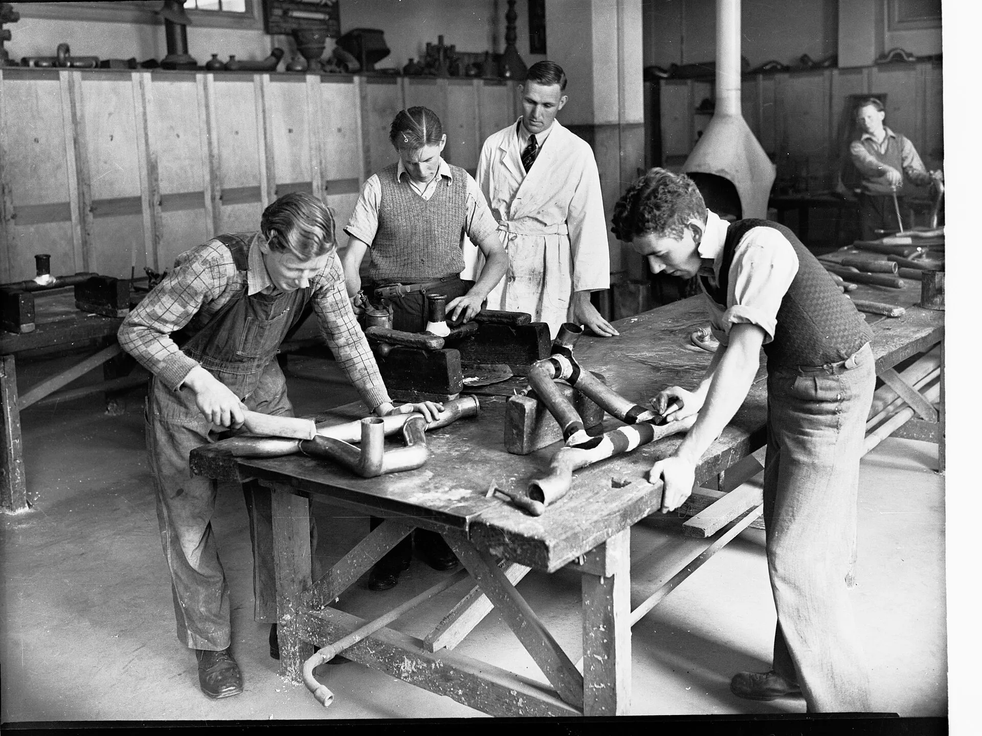 Des apprentis plombiers travaillant sur un réseau de tuyauterie
