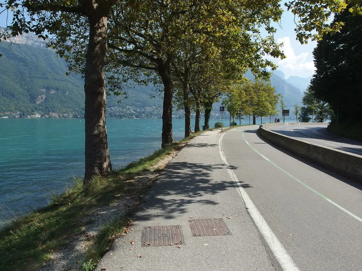 La voie verte du lac d'Annecy le long du plan d'eau, séparée de la route par un muret